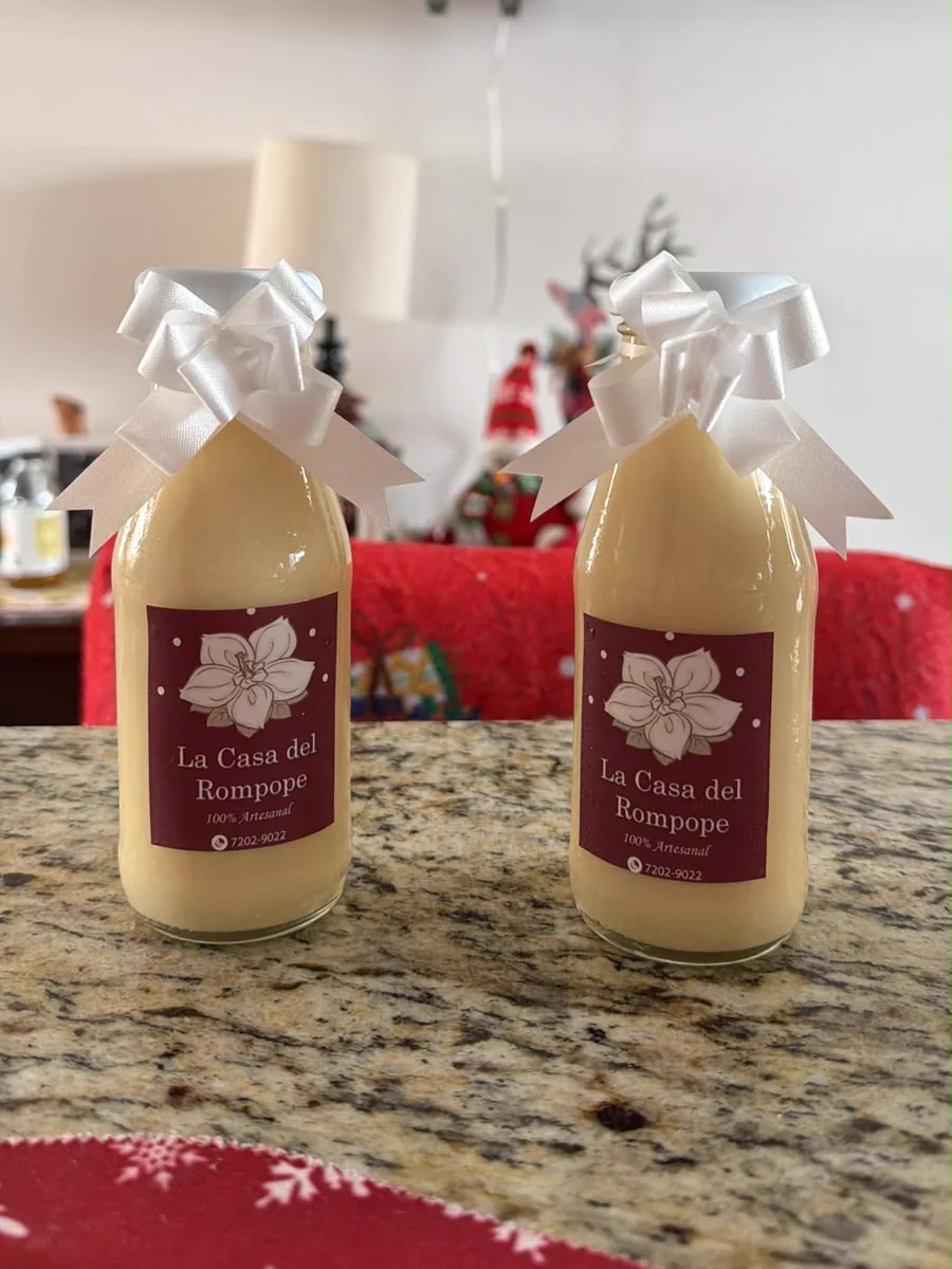 Dos botellas de rompope con moñas blancas
